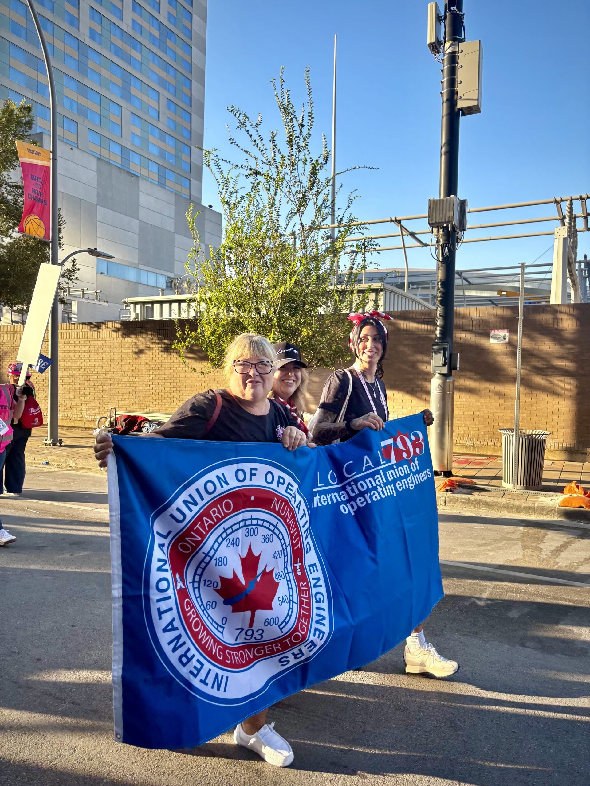 Carla St. Louis leads the way for the IUOE Local 793 delegation with Torie Cocq and Daniella Dines at the banner parade in Houston (Image from IUOE 793 website)